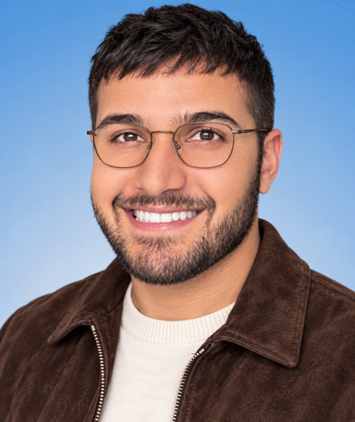AI portrait of Adam with a forward textured crop, close beard, bronze-toned metal glasses, brown suede-style zip jacket and ecru crewneck.