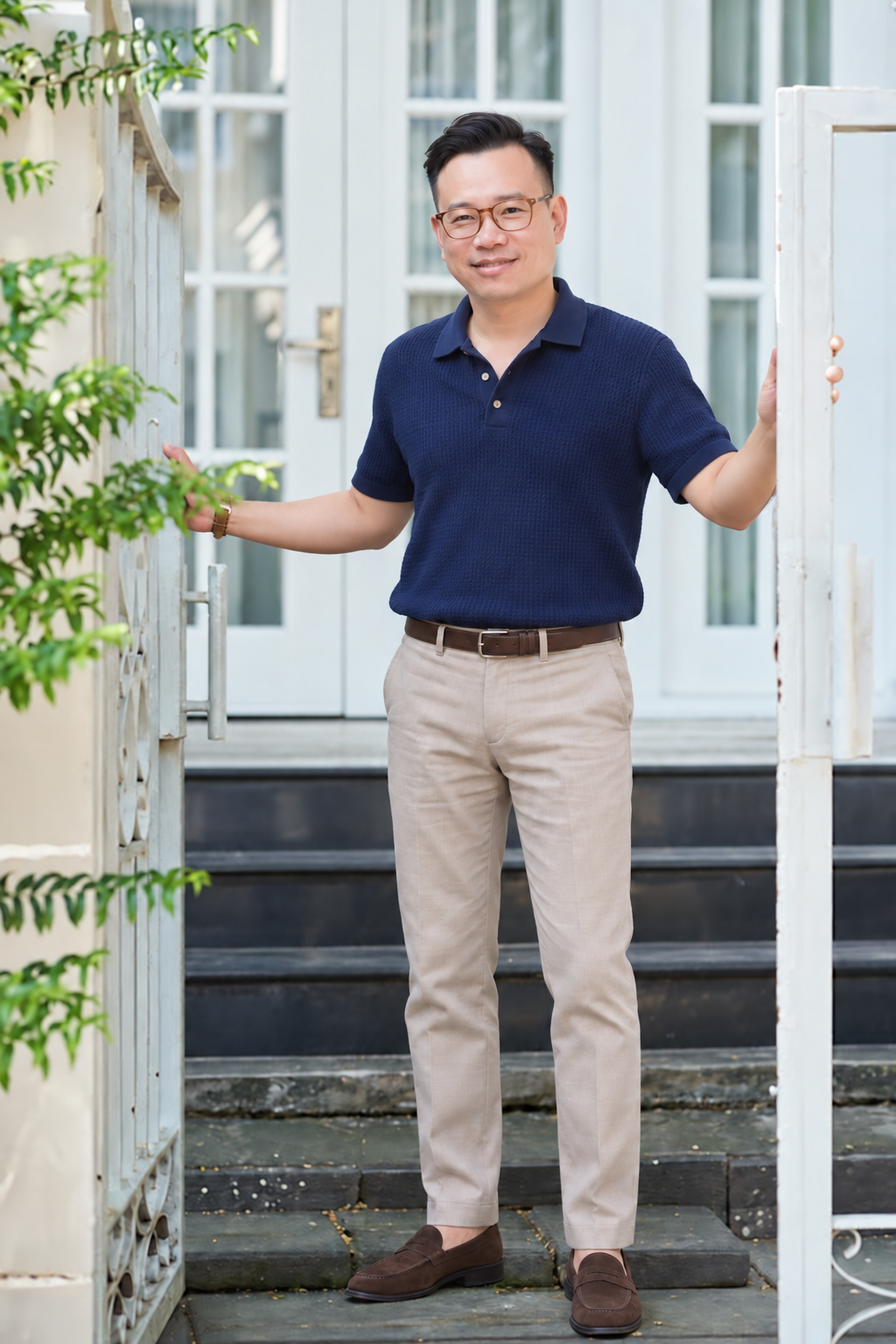 AI style preview of Alex with side-swept hair and brown glasses, wearing a navy knit polo, stone trousers, brown belt and brown loafers.