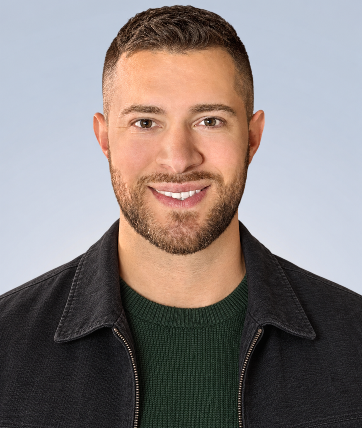 AI styling concept showing a forest-green crewneck, charcoal zip jacket, short textured hair and a close beard.
